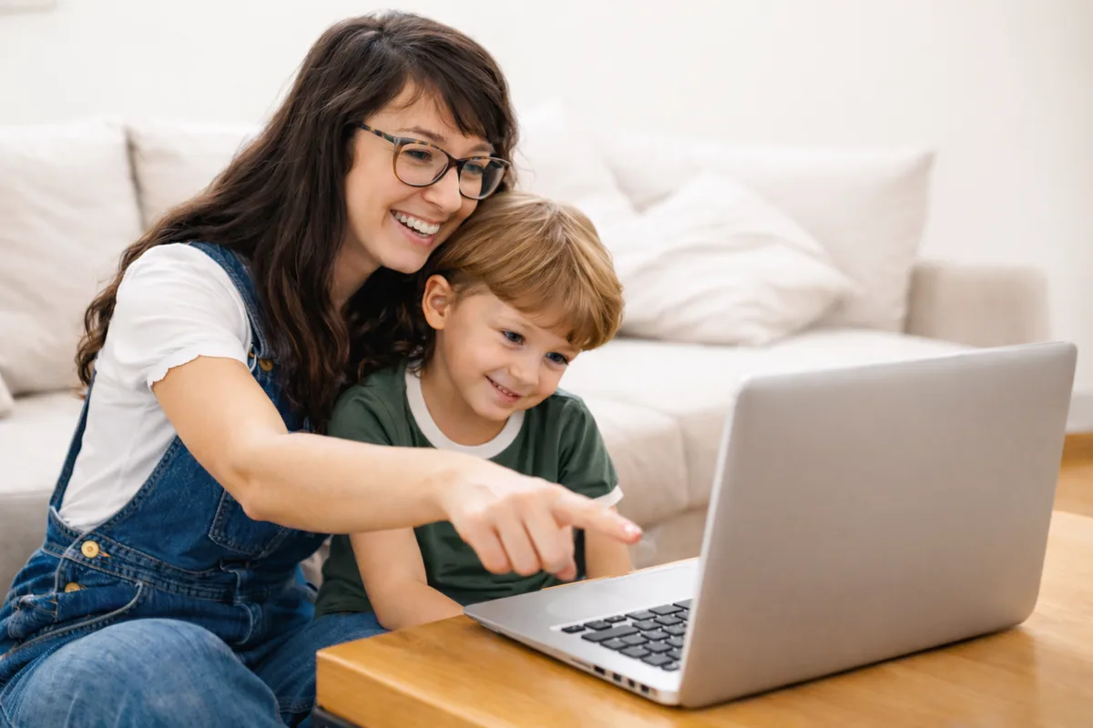 A mother and her son enjoying an online speech therapy session at home